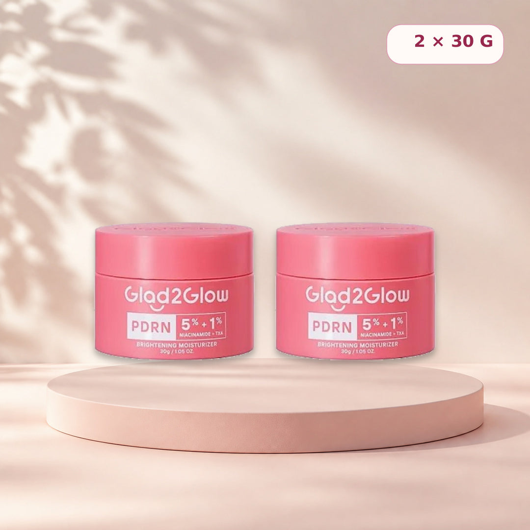 Pack of two Glad2Glow PDRN moisturizers on a pale pink studio pedestal