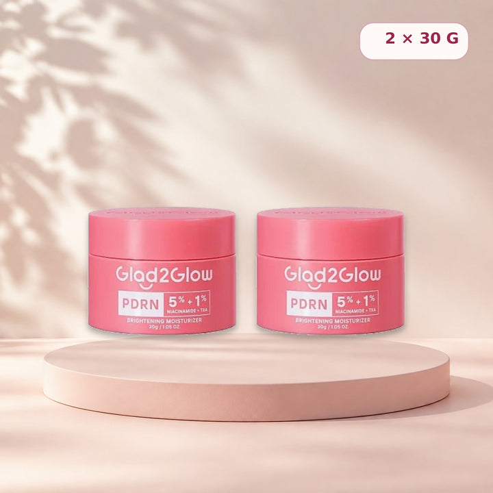 Pack of two Glad2Glow PDRN moisturizers on a pale pink studio pedestal