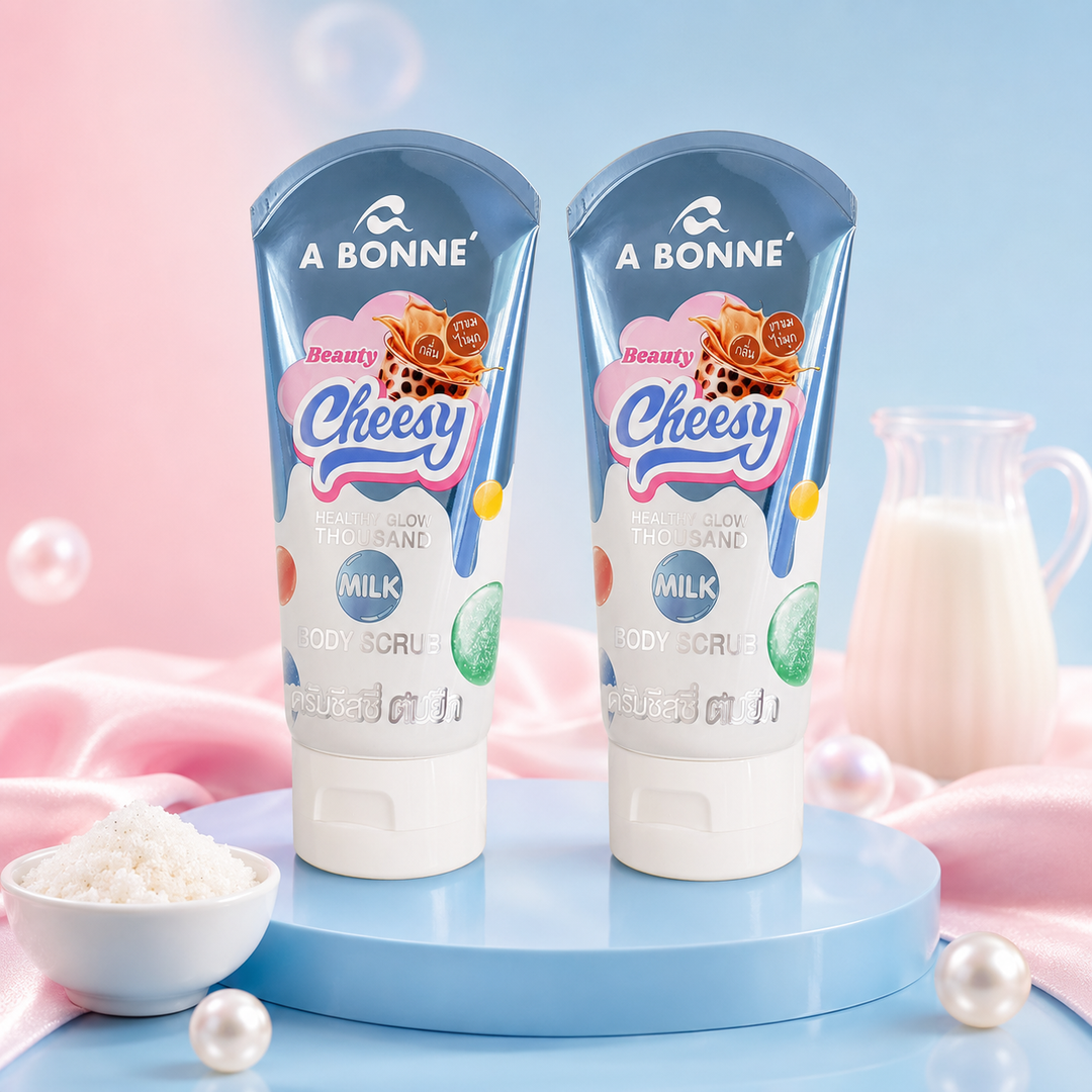 Two A BONNÉ Beauty Cheesy Thousand Milk Body Scrub tubes in a pastel blue and pink spa setting