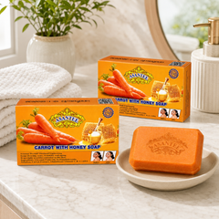 Two boxes and one orange ASANTEE Carrot With Honey Soap bar in a bright bathroom