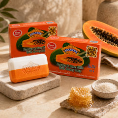 ASANTEE Papaya and Rice Milk with Honey Soap displayed with papaya, rice and honey in a warm spa setting