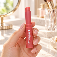 beWiLD Lip Butter, shade 01 Red Yam, held in a hand at a beauty vanity