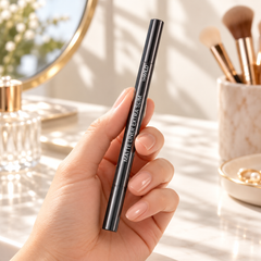 beWiLD Matte Liner Extra Slim, shade 01 Inky, held in a hand at a beauty vanity