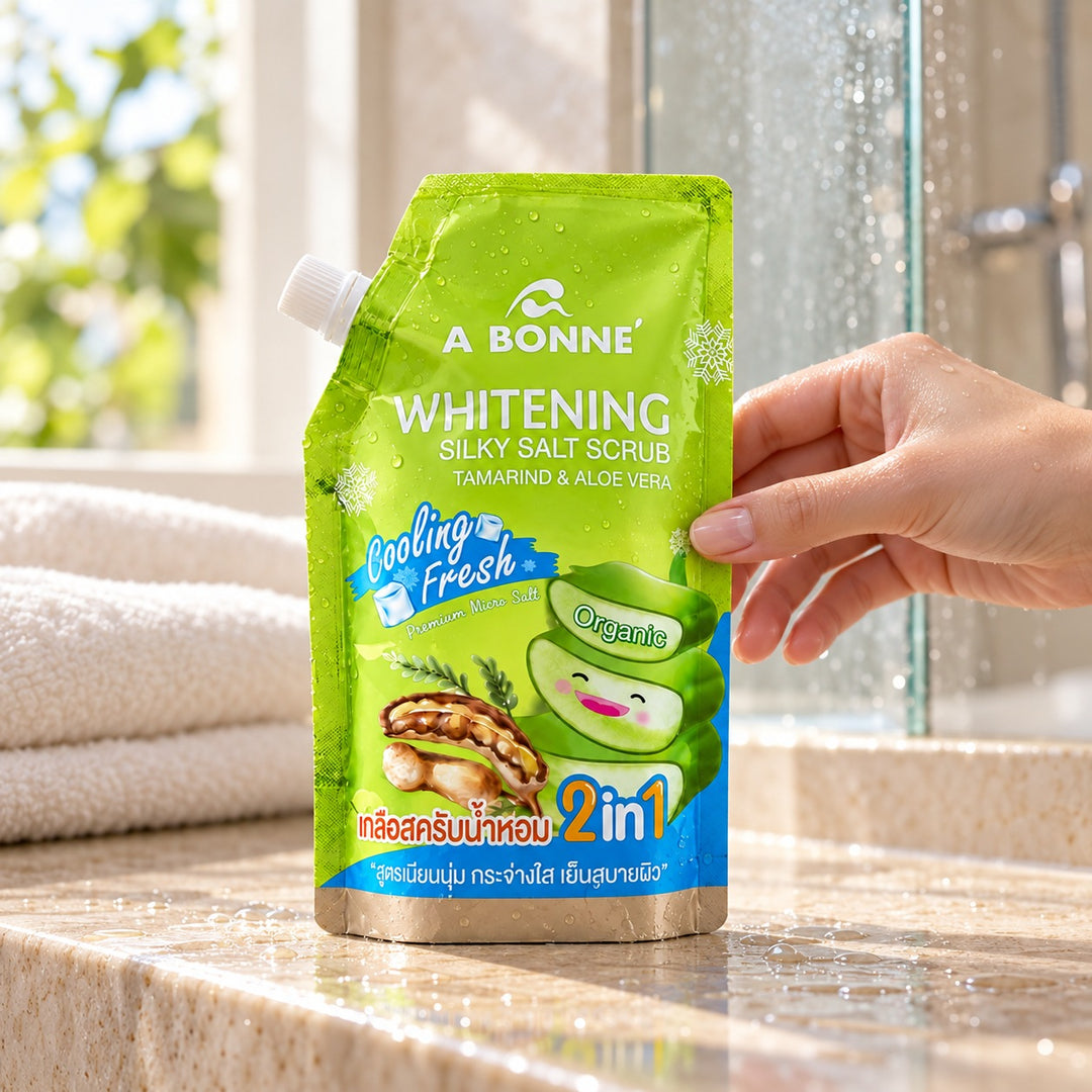 A BONNE Tamarind & Aloe Vera salt scrub pouch being picked up in a shower setting