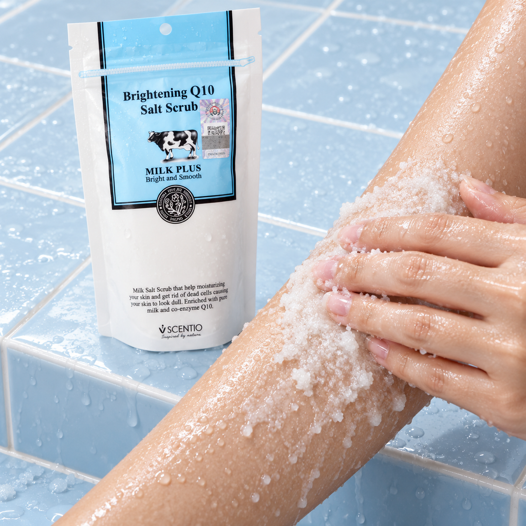 Scentio Milk Plus Brightening Q10 Salt Scrub 300 g — salt scrub being massaged onto an arm