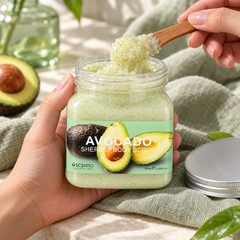 Scentio Avocado Brightening Sherbet Scrub 350 ml — open avocado scrub jar held with a wooden spatula