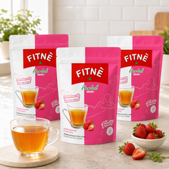 Three packs of FITNÉ Strawberry Herbal Infusion with prepared herbal tea and strawberries