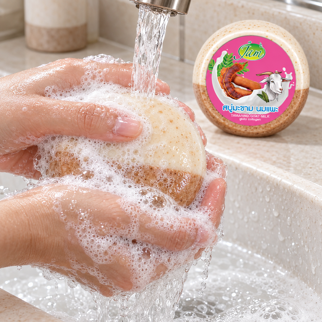 Hands lathering JAM Tamarind Goat Milk Collagen Round Soap under running water