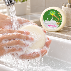 Hands lathering JAM Rice Milk Gluta Collagen Round Soap under running water