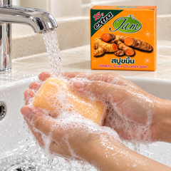 Hands lathering JAM Turmeric Gluta Collagen Soap under running water