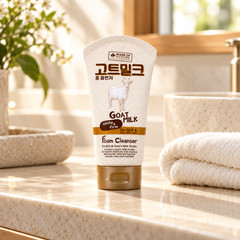 Made in Nature Goat Milk White & Firm Foam Cleanser 100 ml on a stone bathroom vanity beside a folded ivory towel